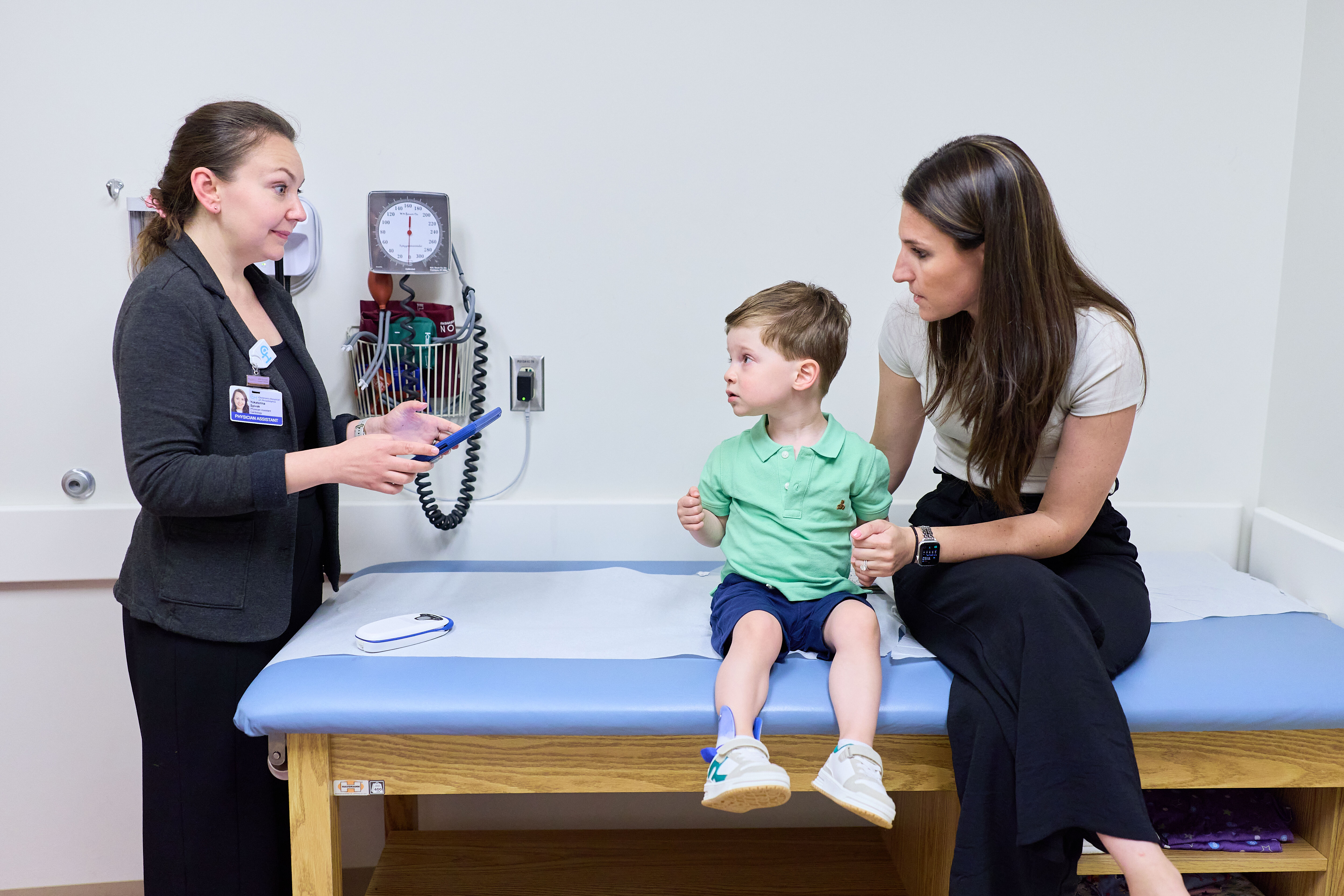 A photo of a doctor, a child and his mom.
